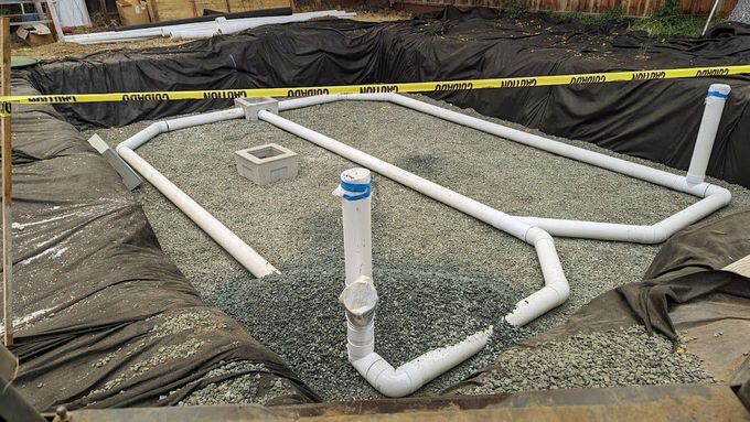 A bunch of pipes are sitting on top of a pile of gravel.