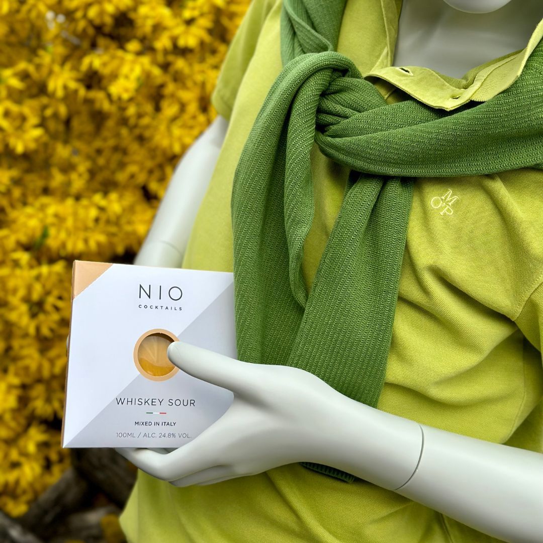 Eine Schaufensterpuppe mit einem grünen Schal hält eine Schachtel mit der Aufschrift „Nio“