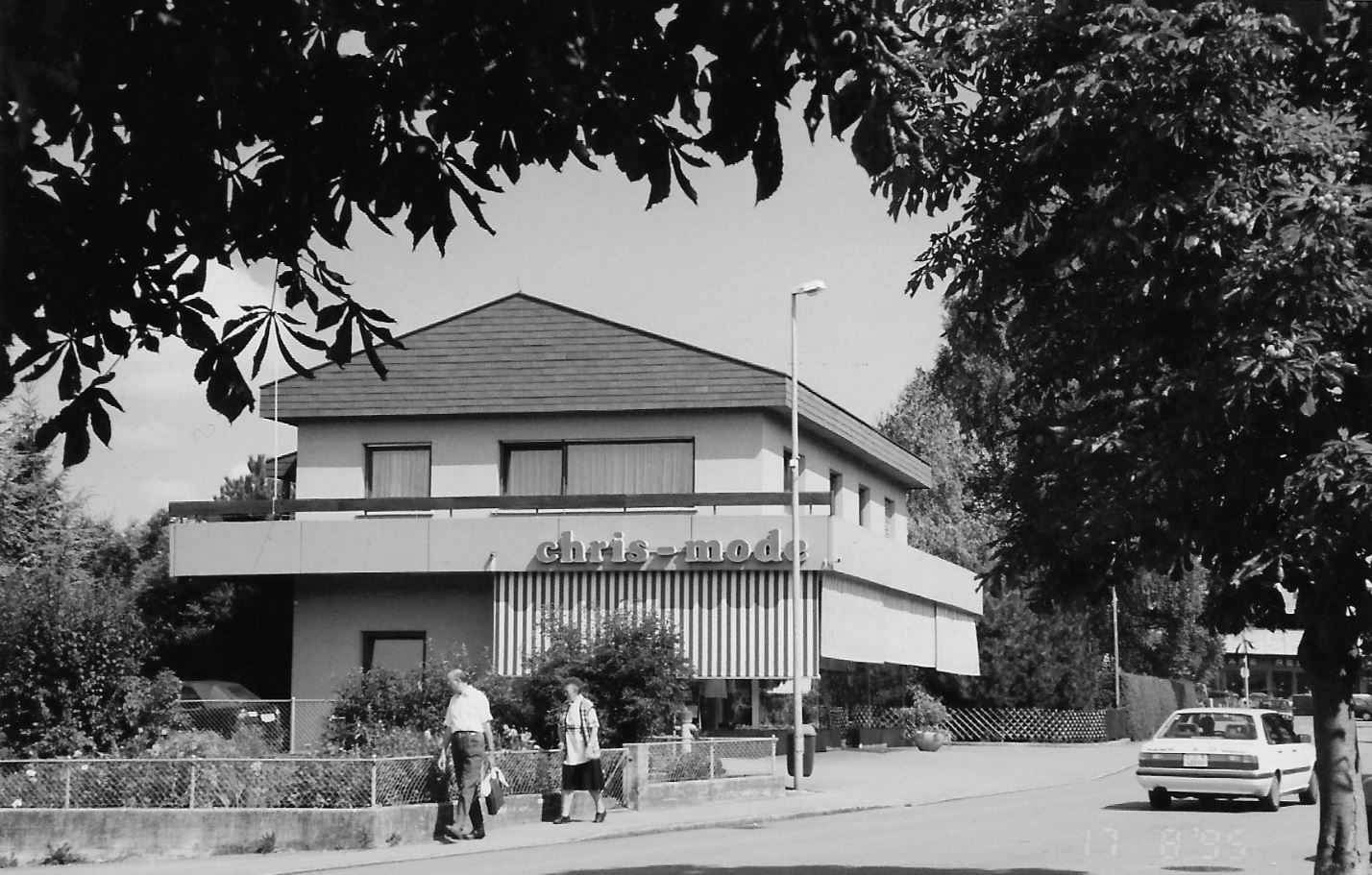 Ein Schwarzweißfoto eines Hauses mit einem davor geparkten Auto