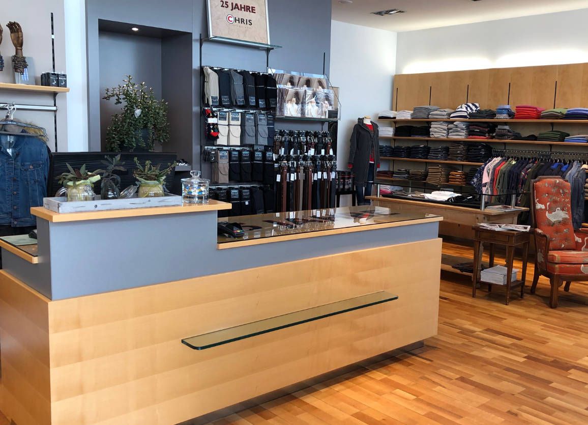 Ein Laden mit einer Holztheke und einem roten Stuhl.