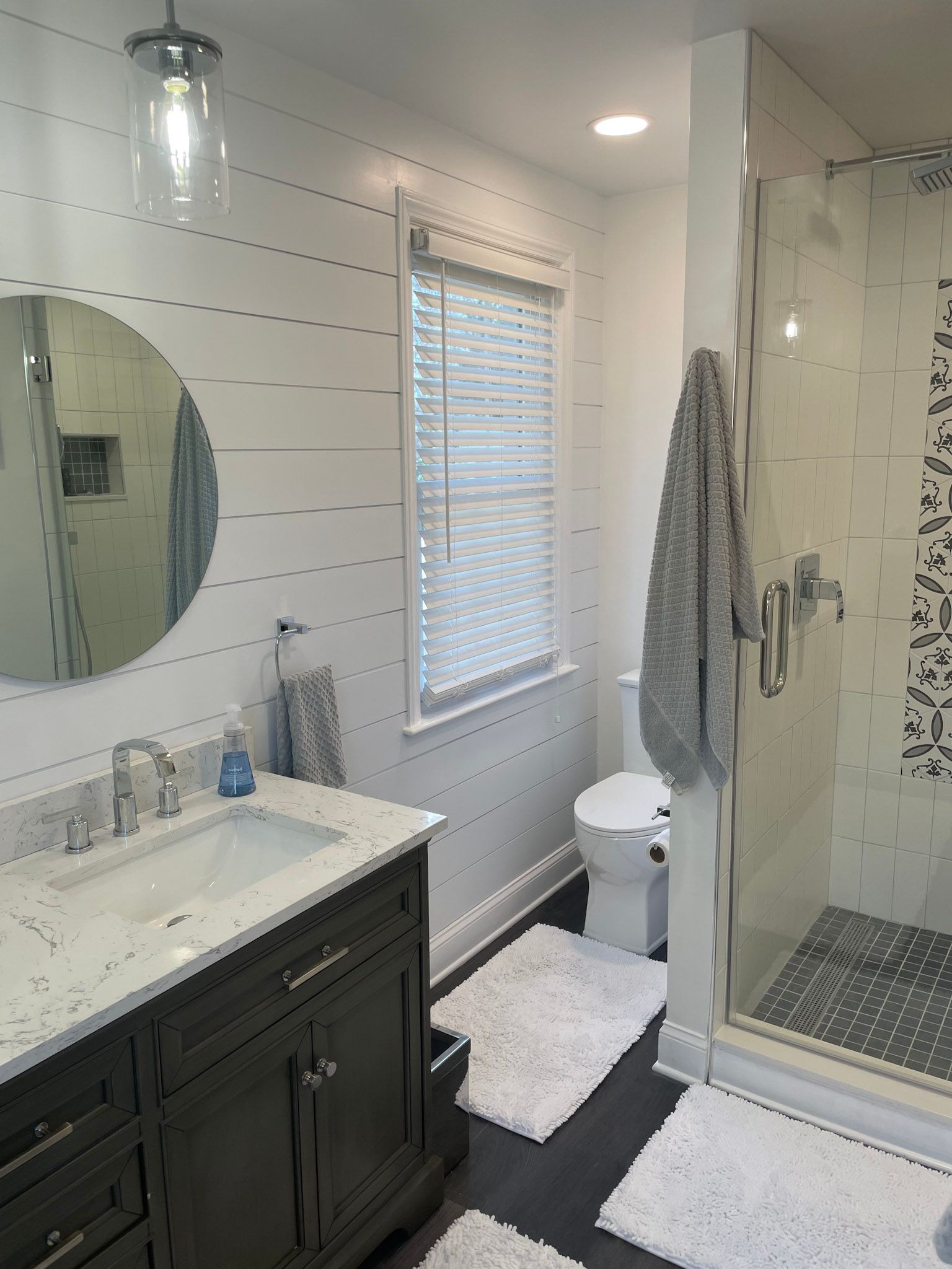 a bathroom with a sink , toilet , shower and mirror .