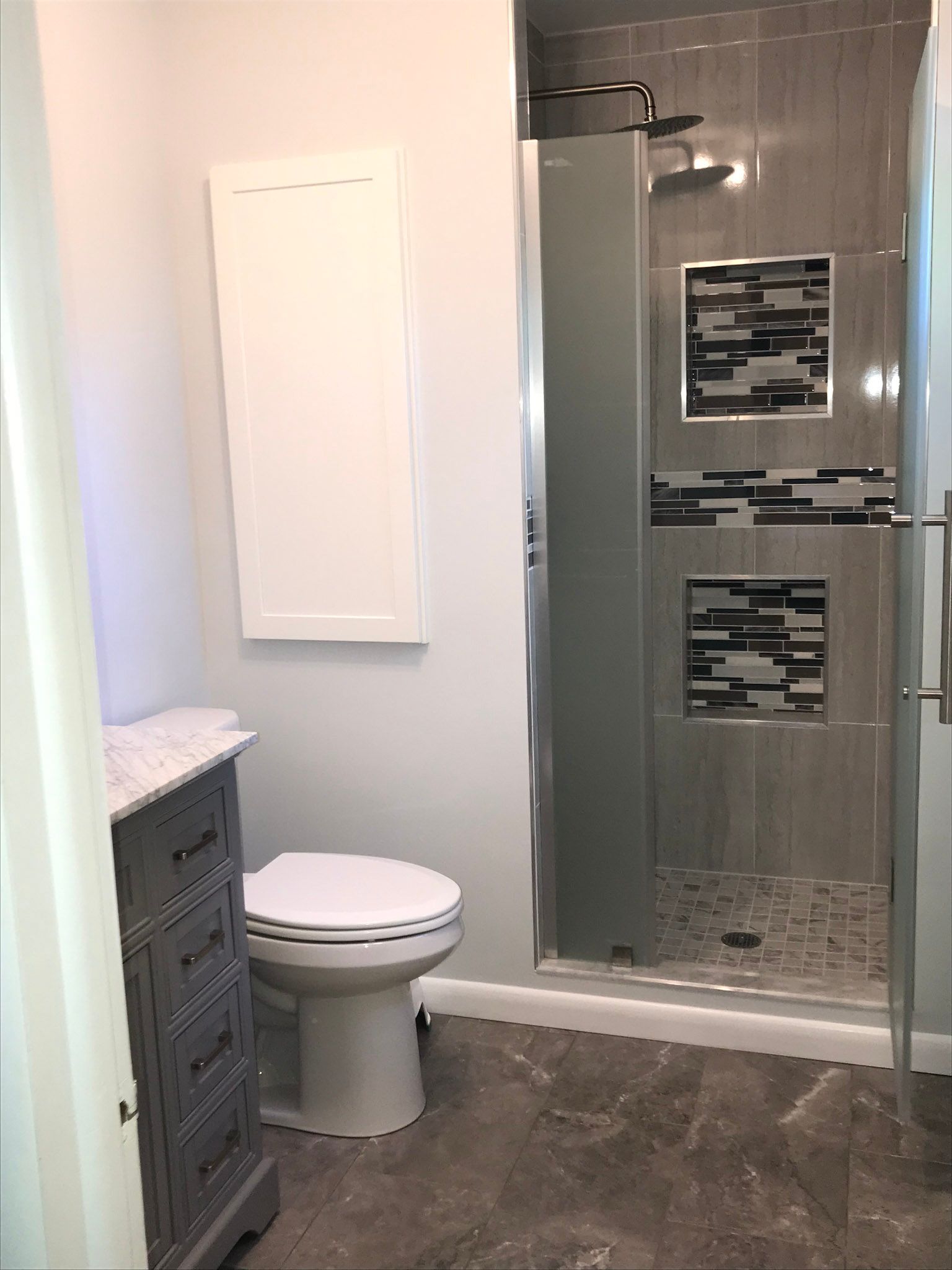 a bathroom with a toilet and a walk in shower .