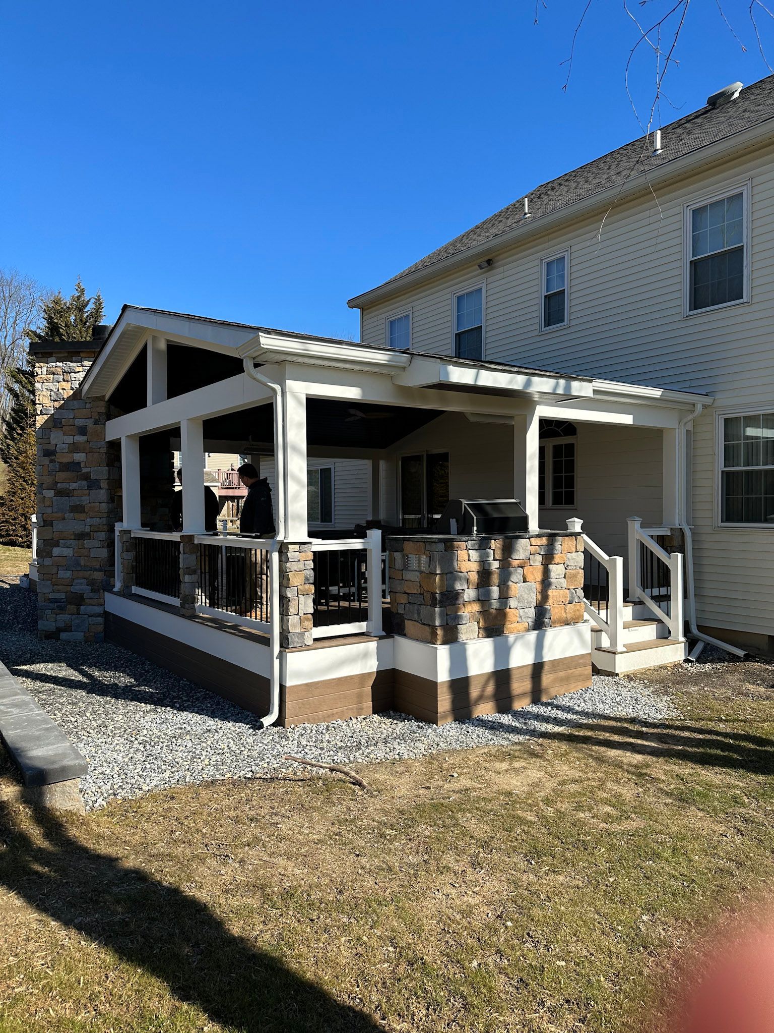 a house with a porch and a fireplace in the backyard .