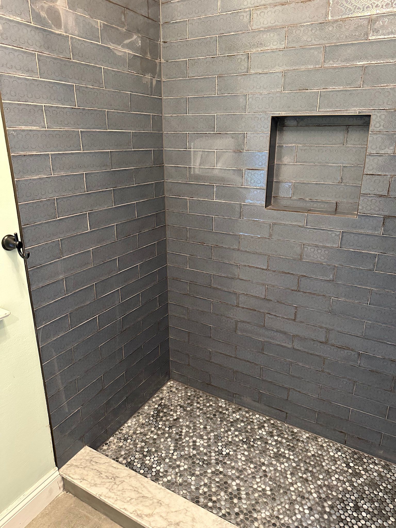 a bathroom with a walk in shower and a brick wall .