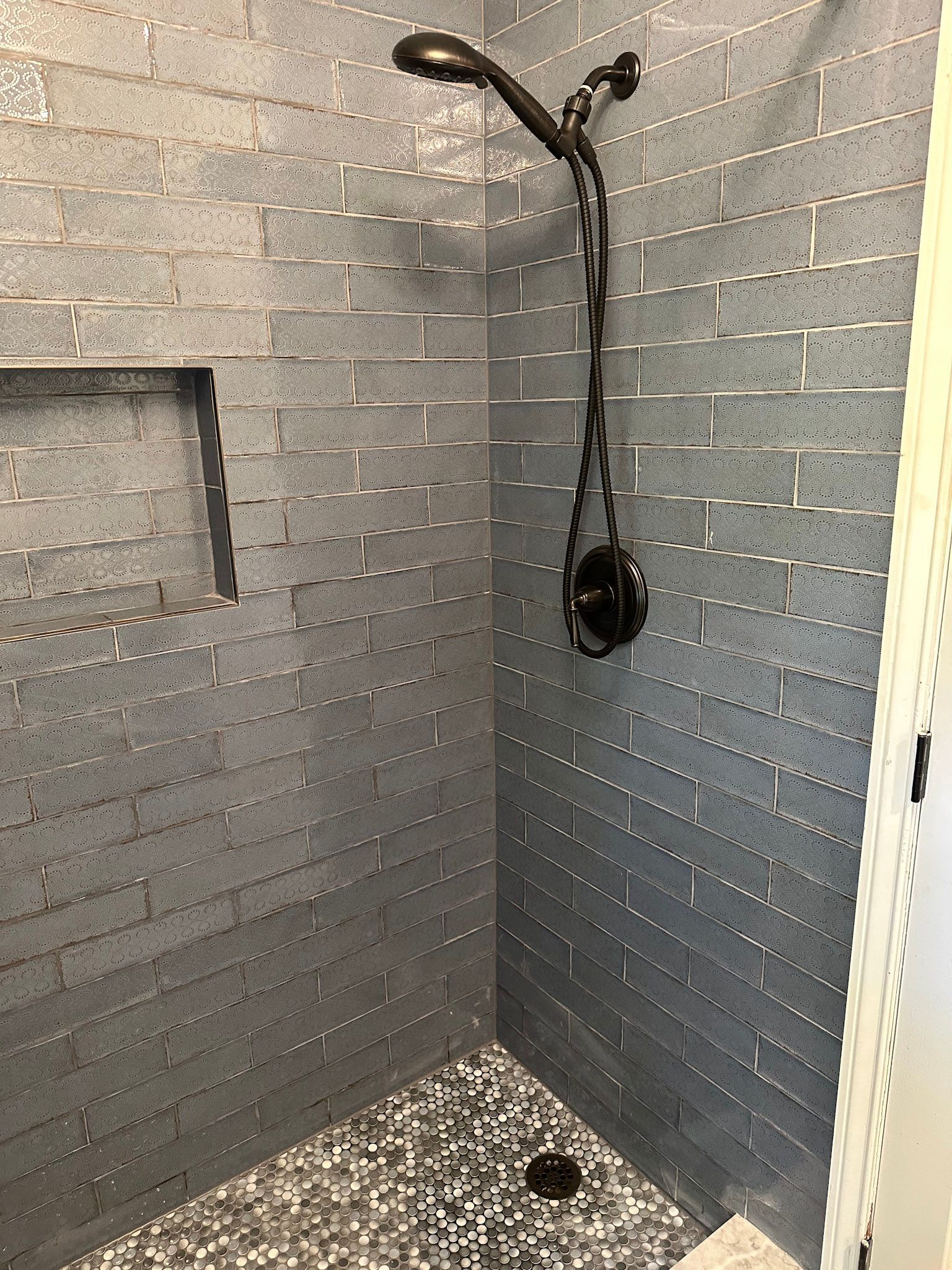 a shower with a shower head and a brick wall .