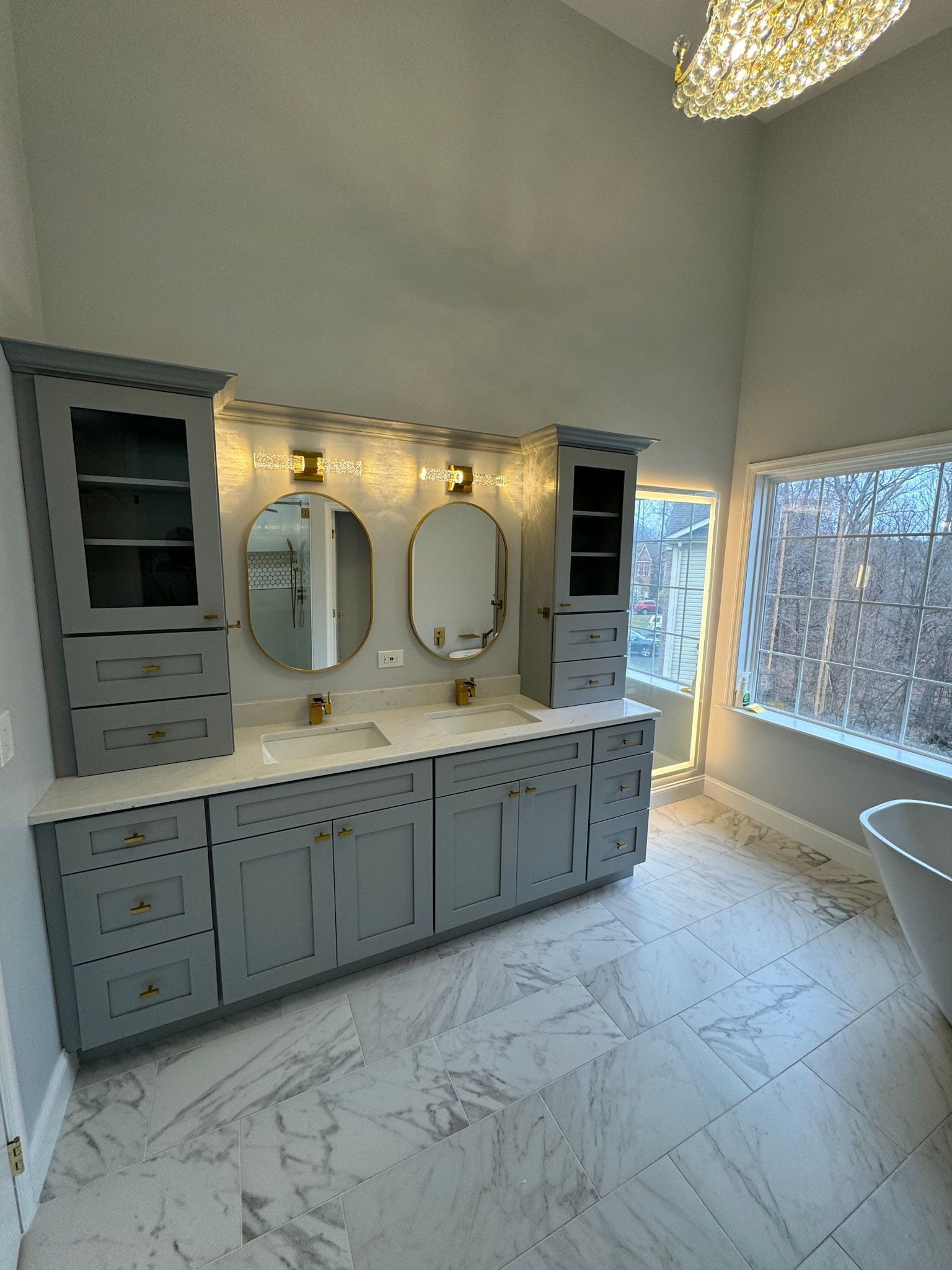 a bathroom with two sinks , two mirrors and a tub .