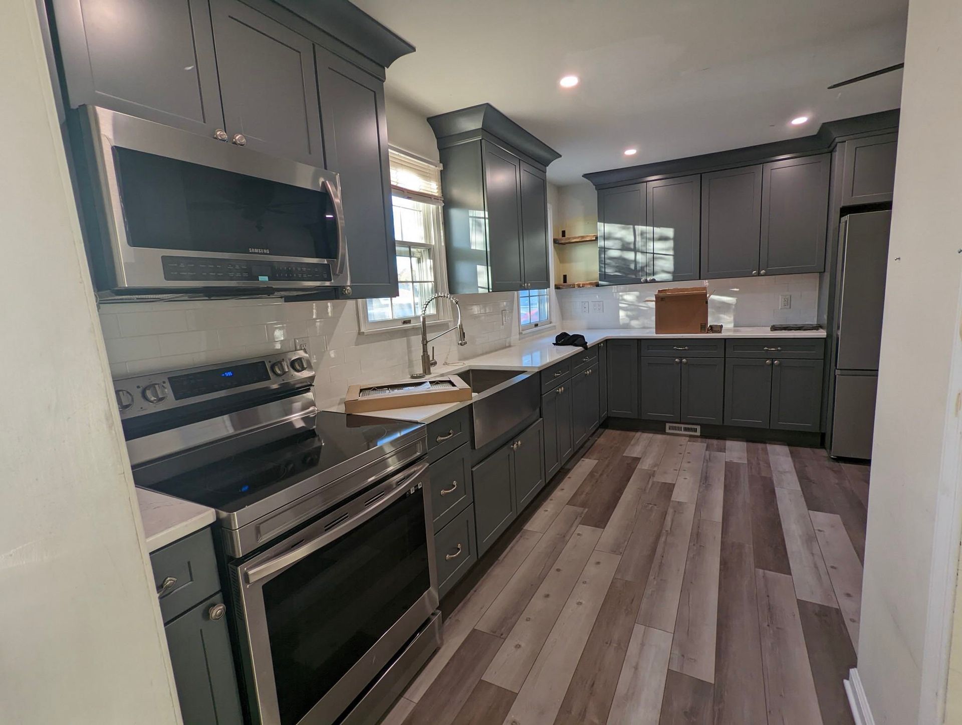 a kitchen with gray cabinets and stainless steel appliances
