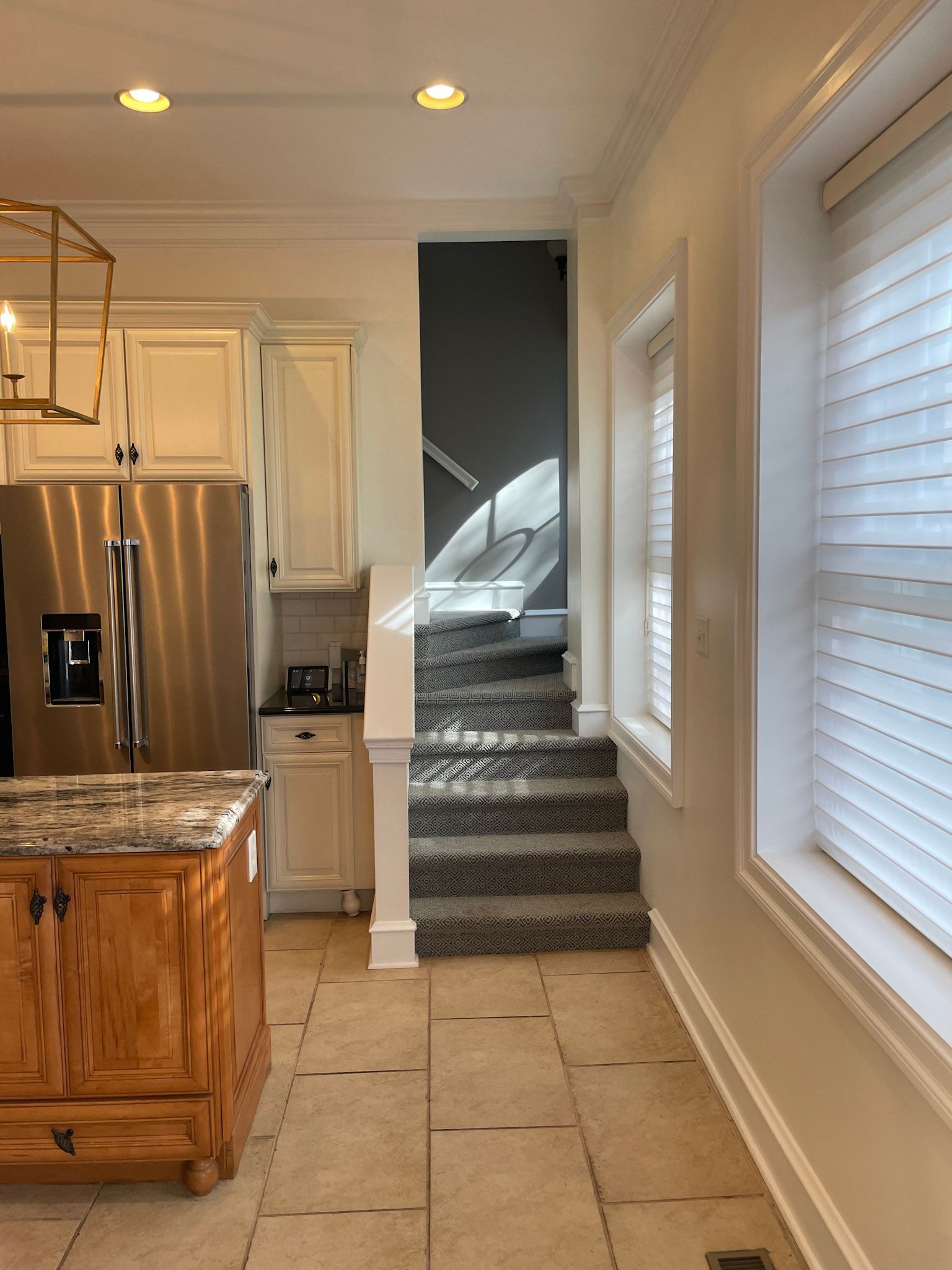 a kitchen with a staircase leading up to the second floor
