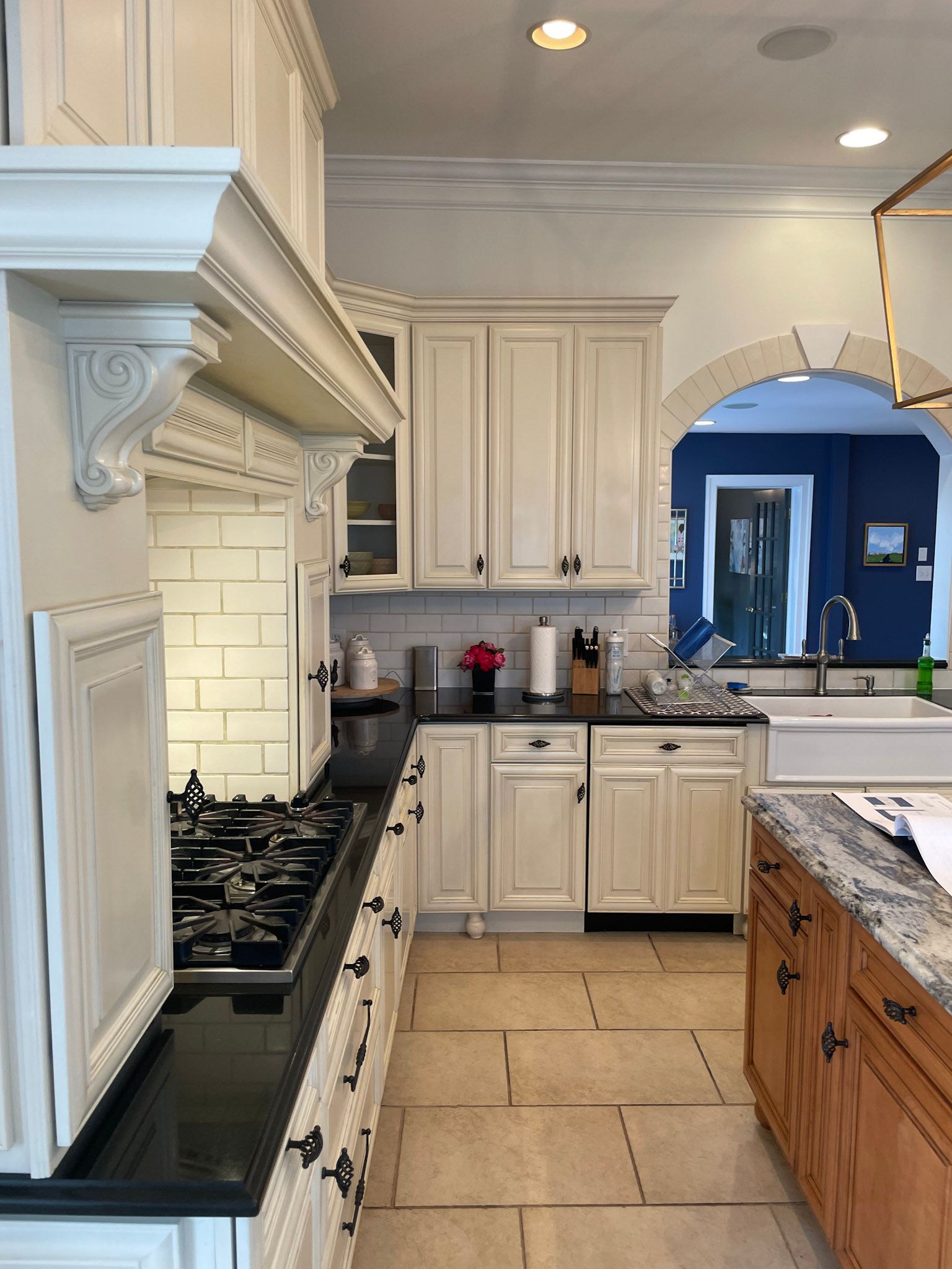 a kitchen with white cabinets and black counter tops