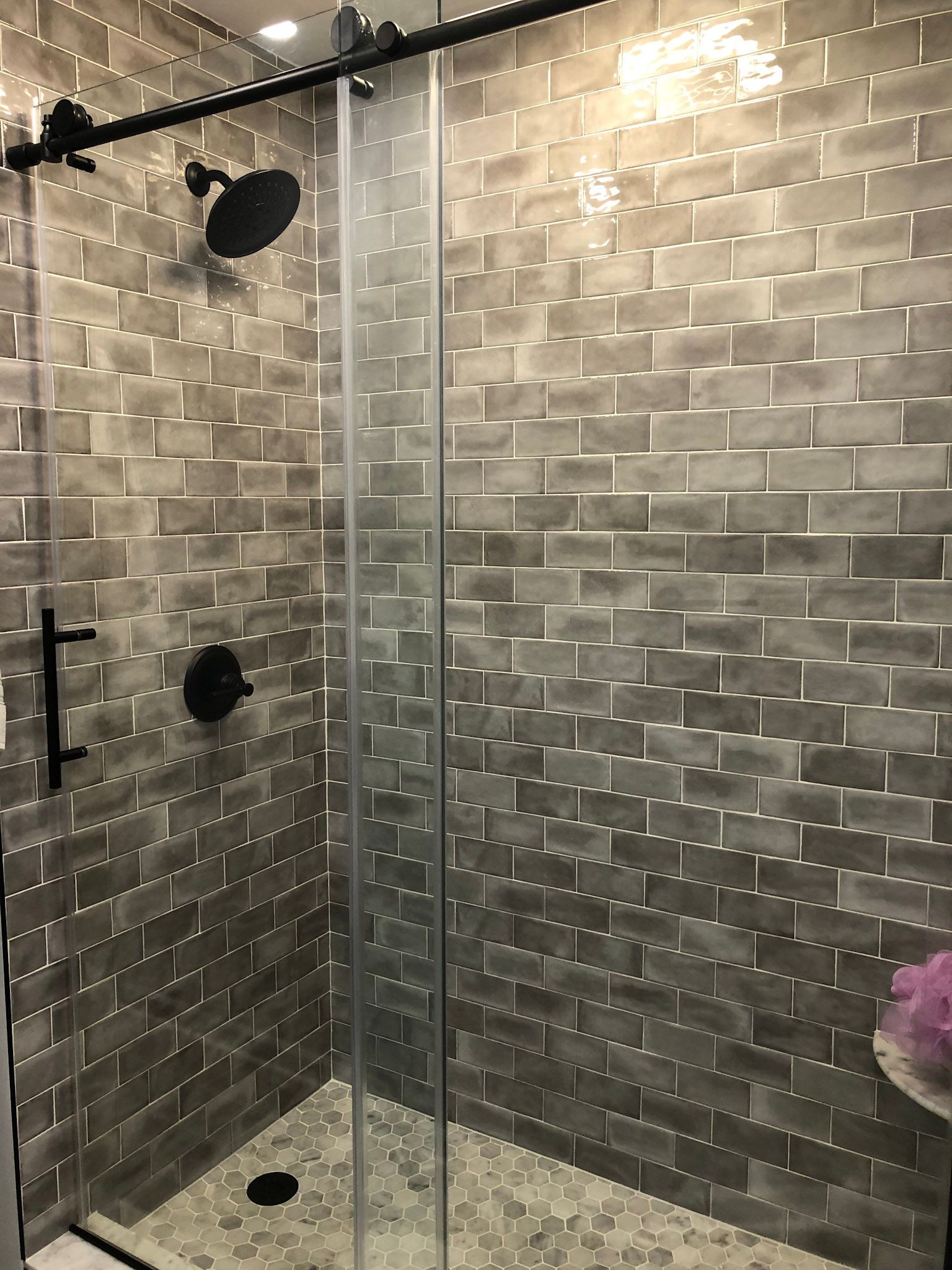 a shower with a sliding glass door and a black shower head .