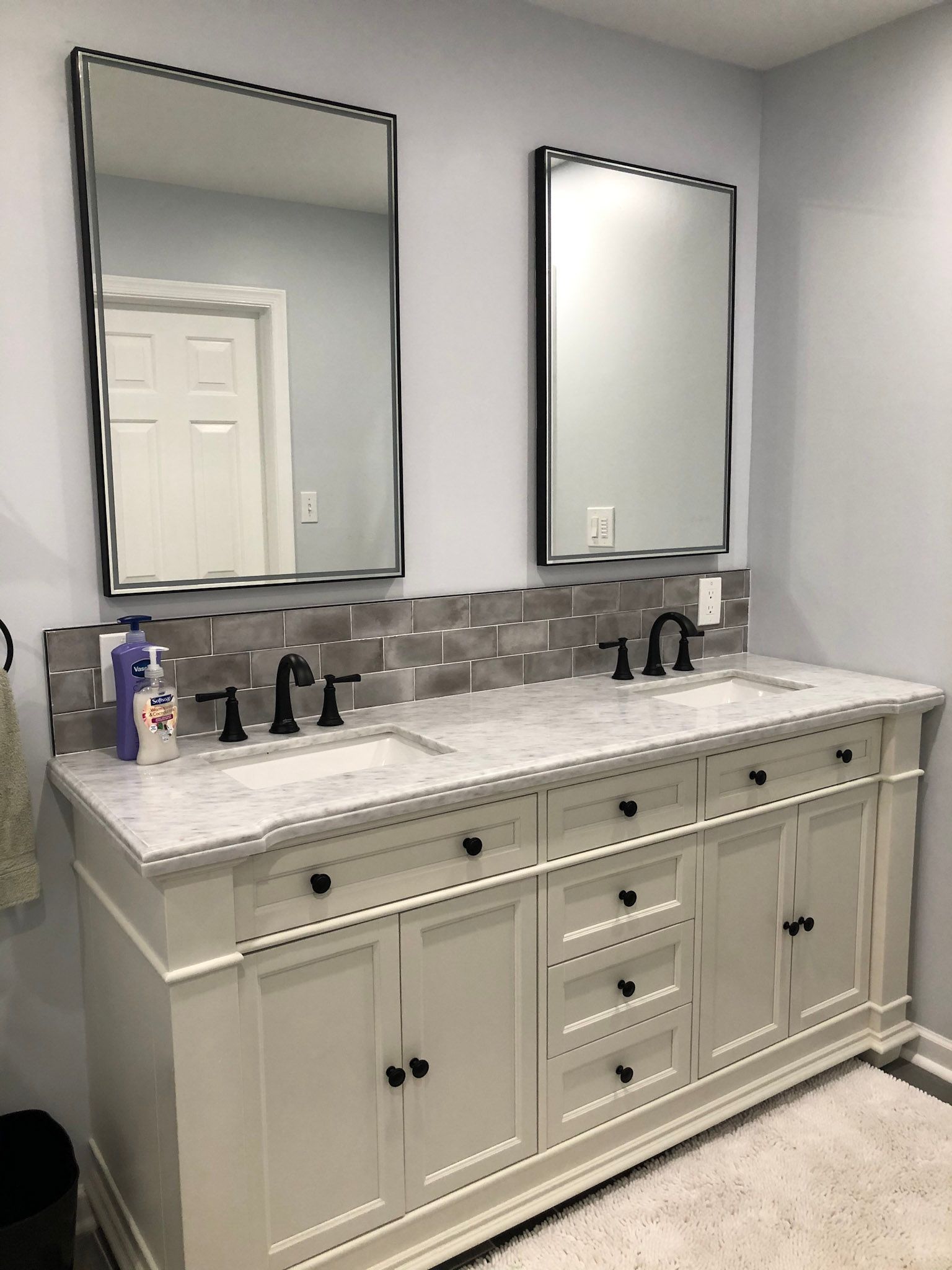 a bathroom with two sinks and two mirrors .