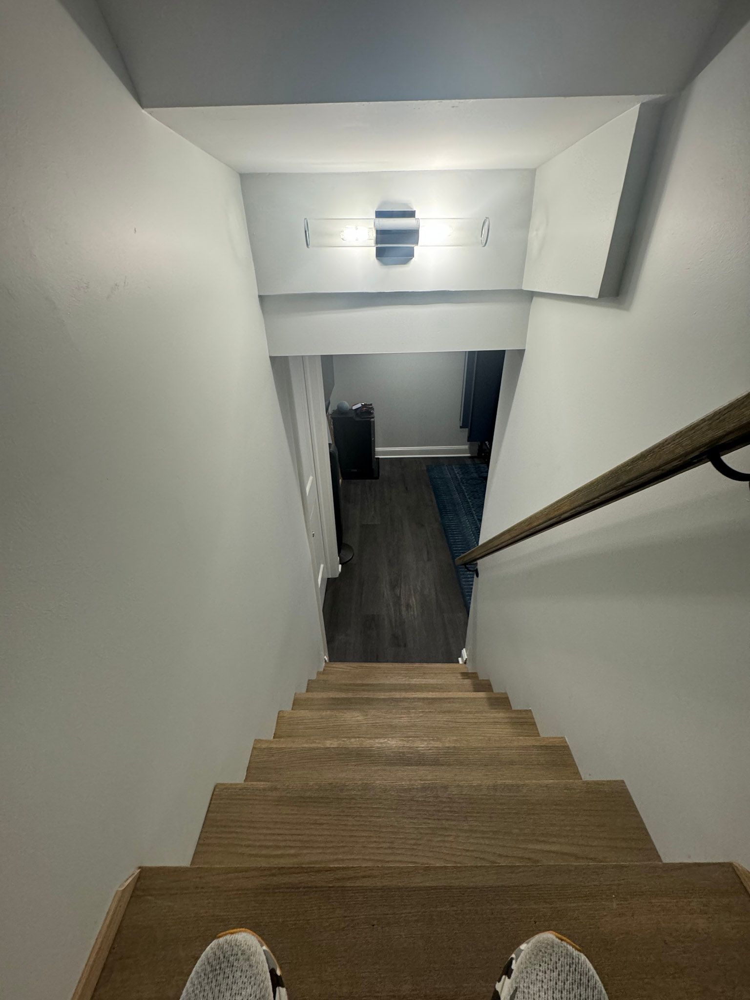 a person is standing on the bottom of a set of wooden stairs .