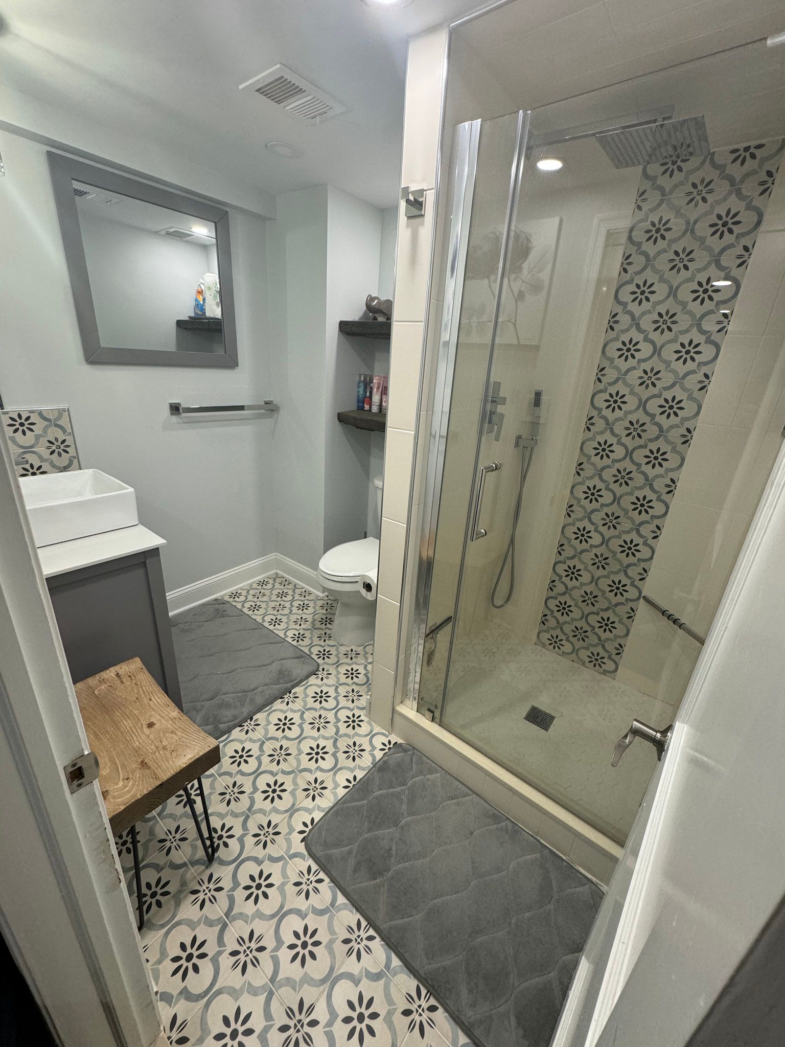 a bathroom with a walk in shower , sink , toilet and mirror .