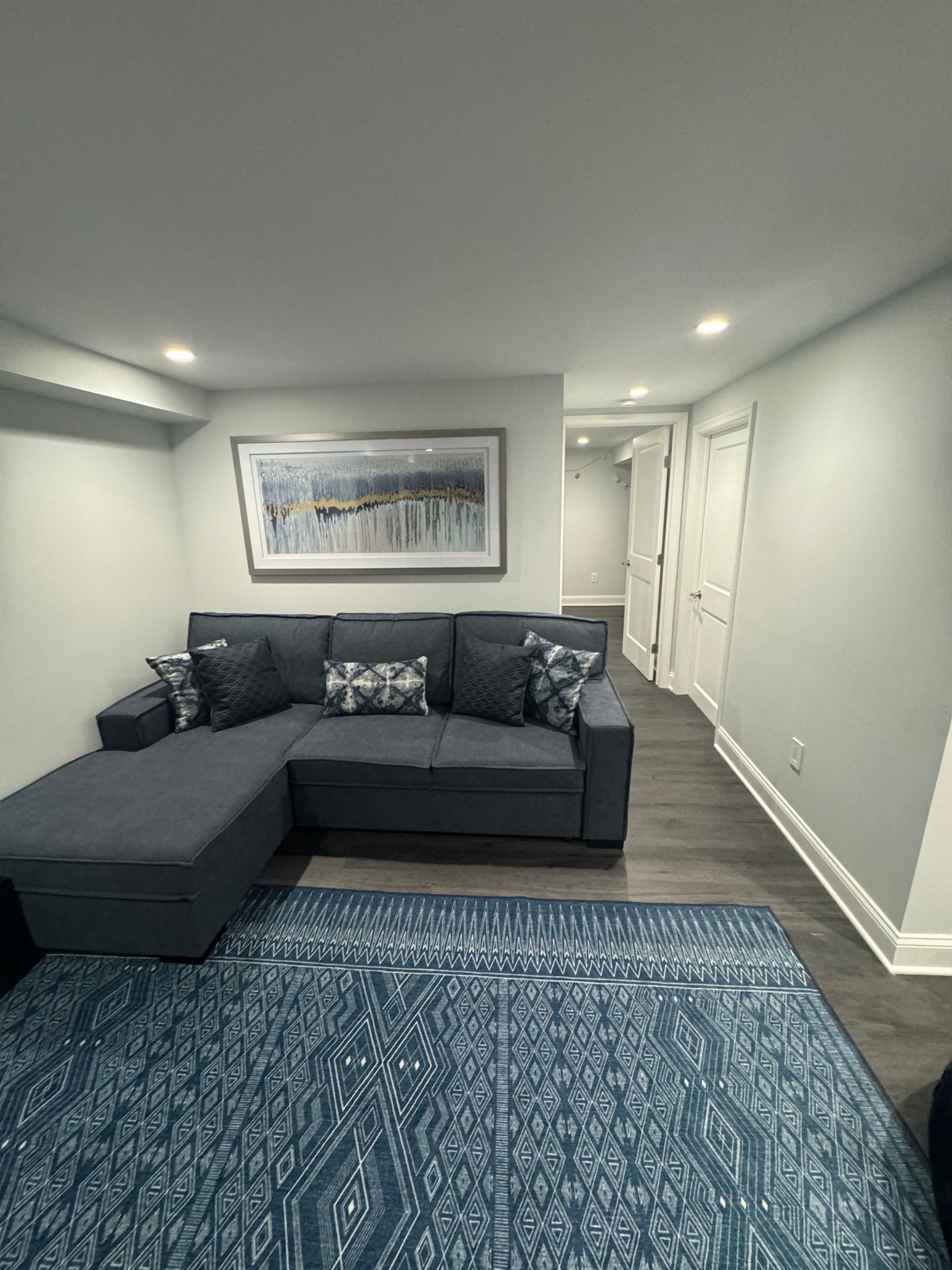 a living room with a couch , rug , and painting on the wall .
