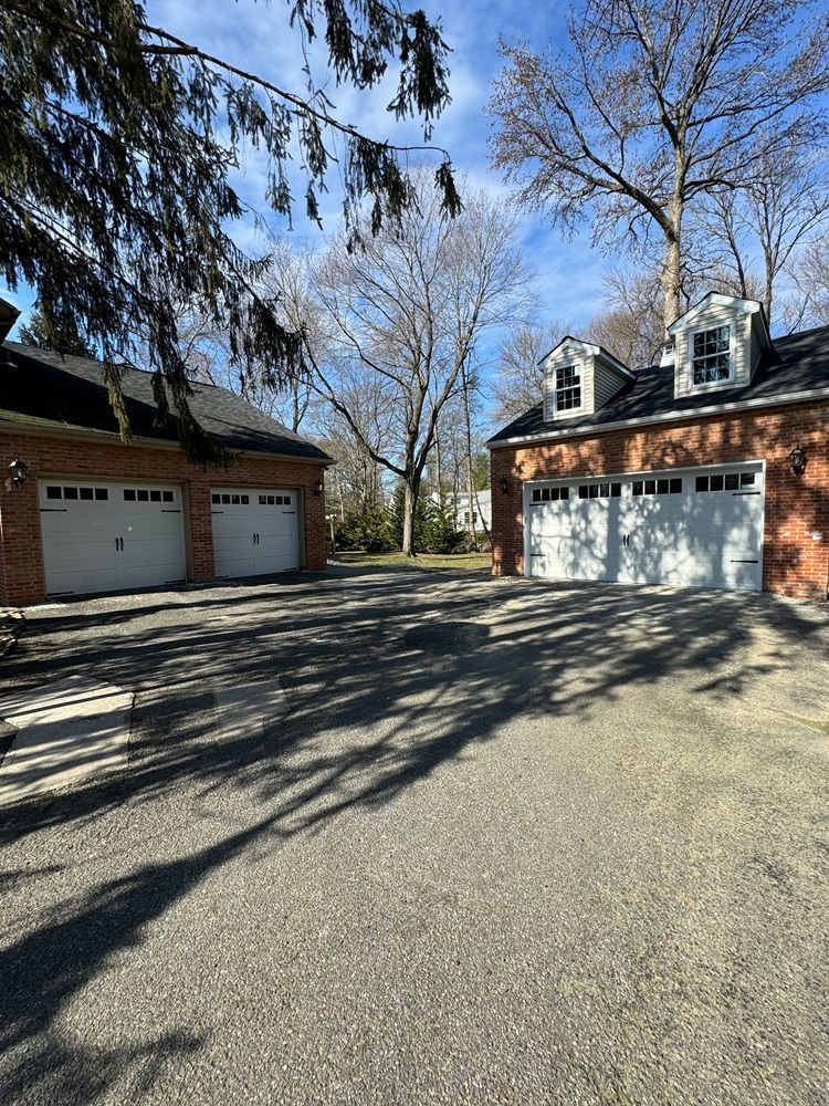 there are three garage doors in front of a brick house .