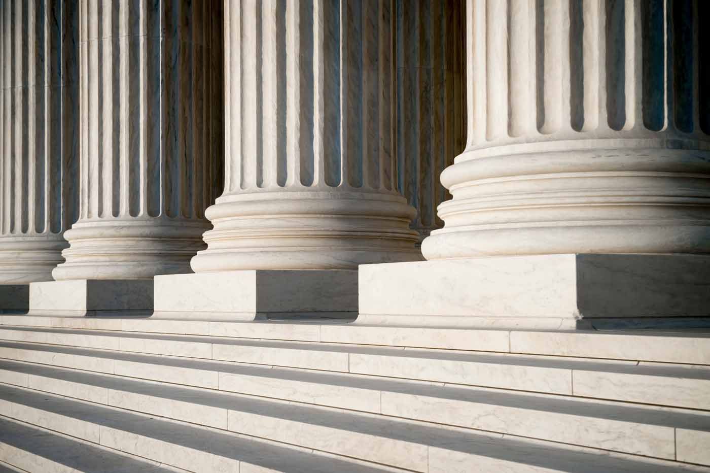 A row of columns and steps in front of a building.