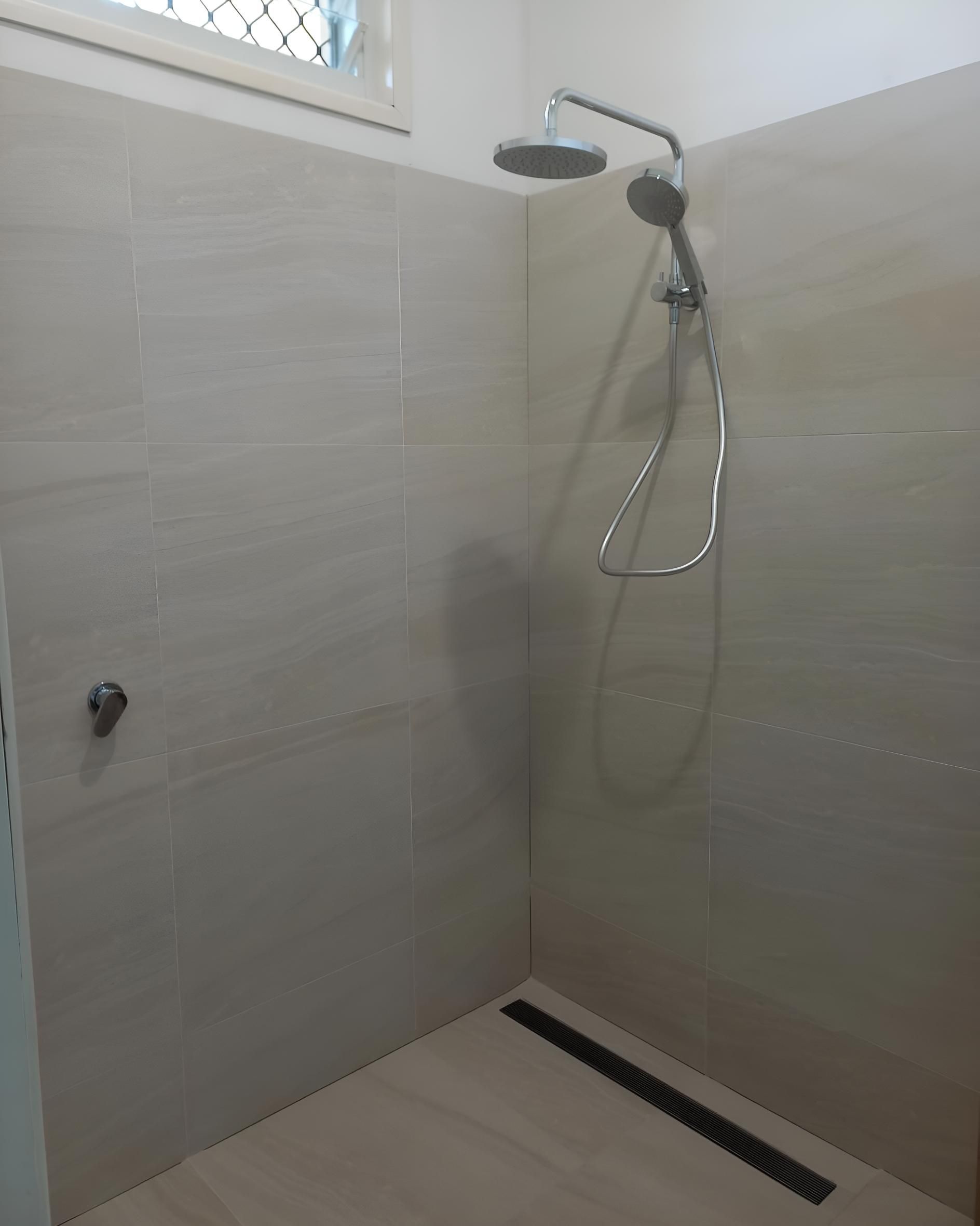 Shower With a Shower Head and a Window — Luke Barry Plumbing in Main Beach, QLD