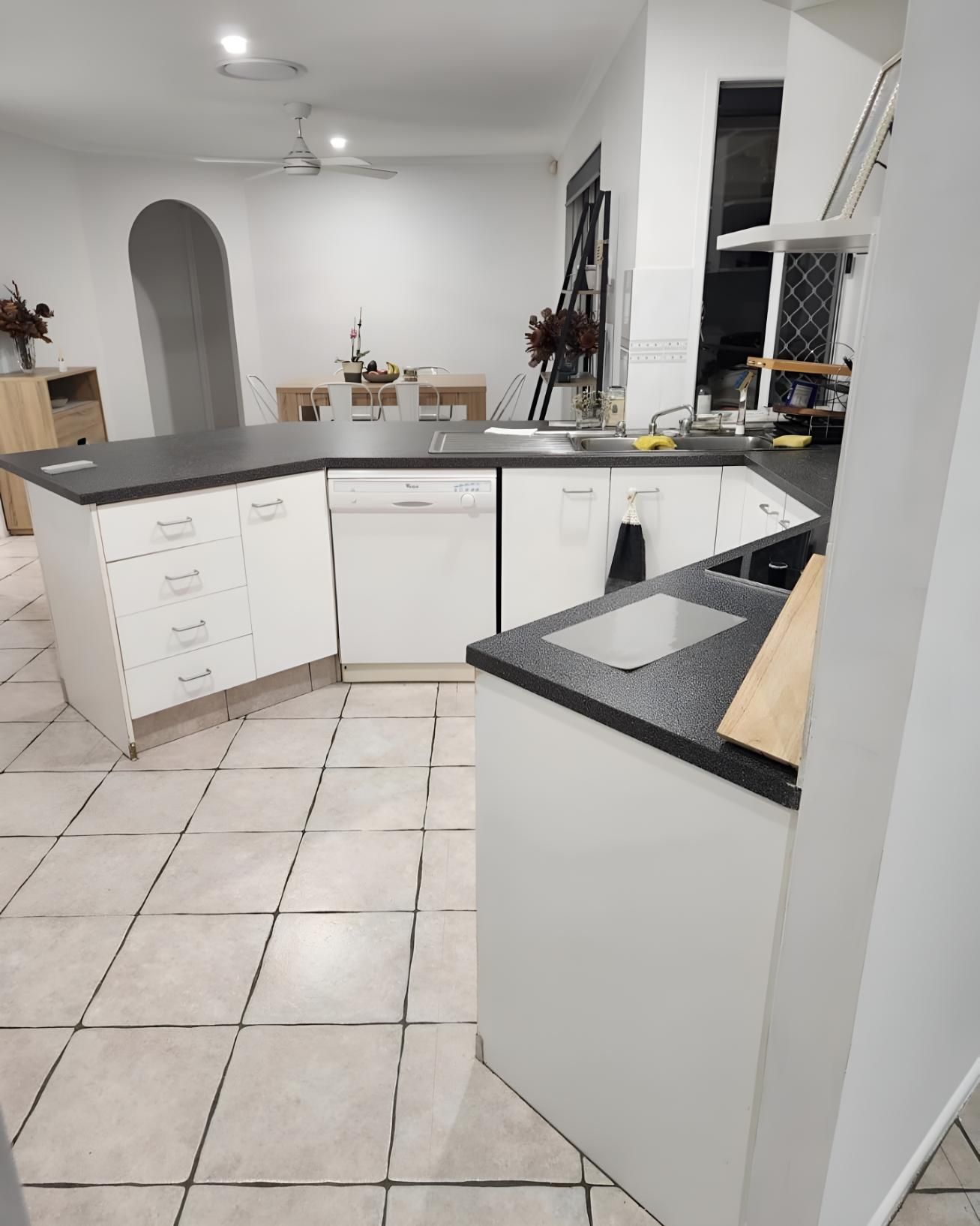 Kitchen With White Cabinets and Black Counter Tops — Luke Barry Plumbing in Mermaid Beach, QLD
