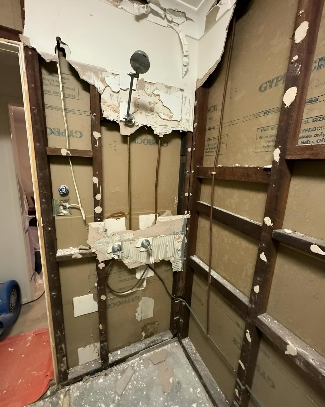 Bathroom With a Broken Wall and a Shower Head — Luke Barry Plumbing in Palm Beach, QLD