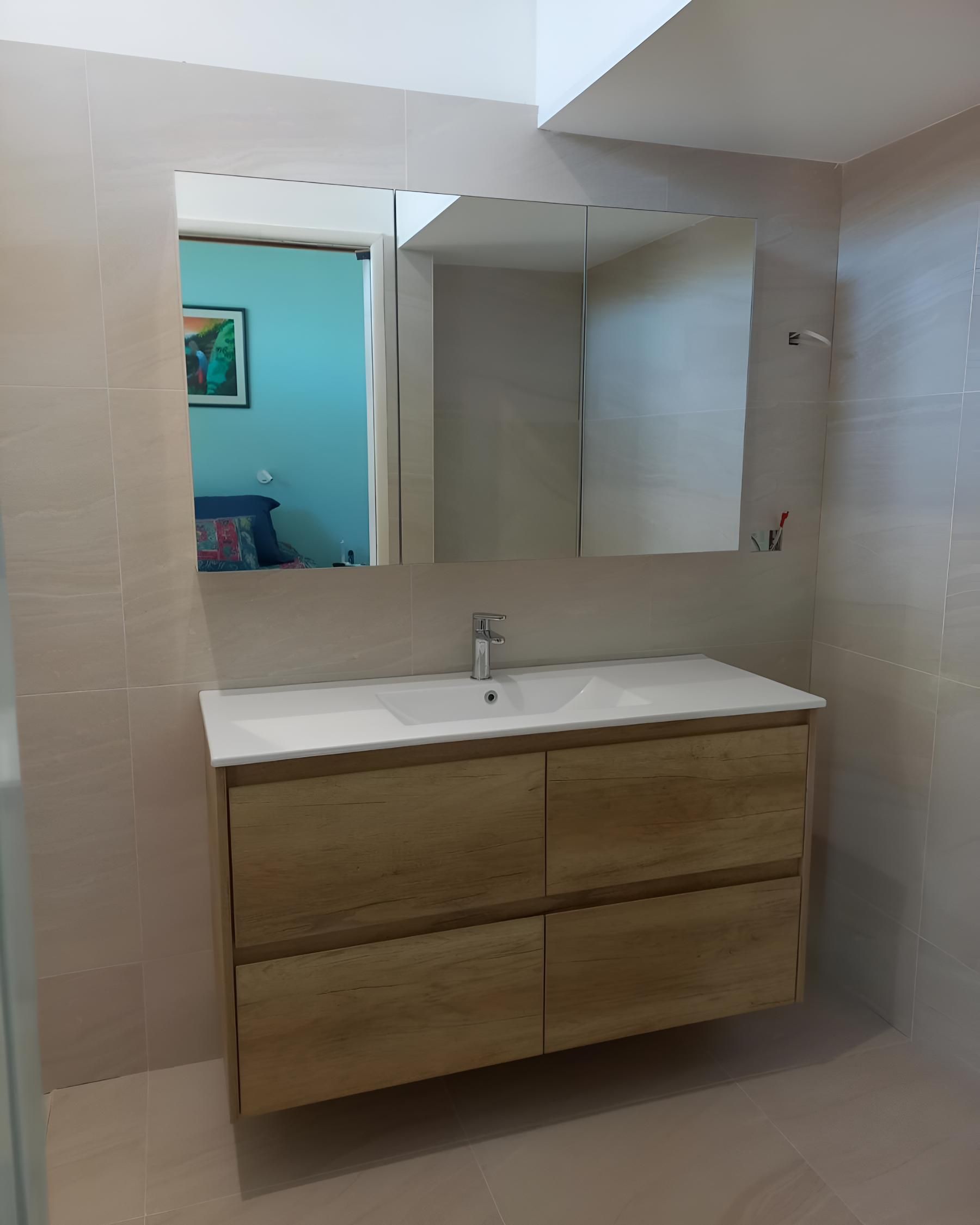 Bathroom With a Sink, Mirror and Drawers — Luke Barry Plumbing in Helensvale, QLD