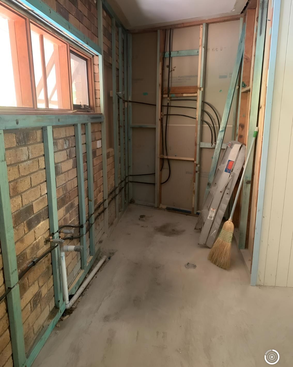Room With Brick Walls and a Broom on the Floor — Luke Barry Plumbing in Benowa, QLD