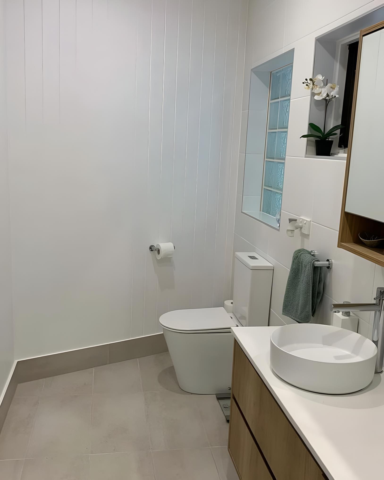 Bathroom With a Toilet, Sink and Mirror — Luke Barry Plumbing in Broadbeach Waters, QLD