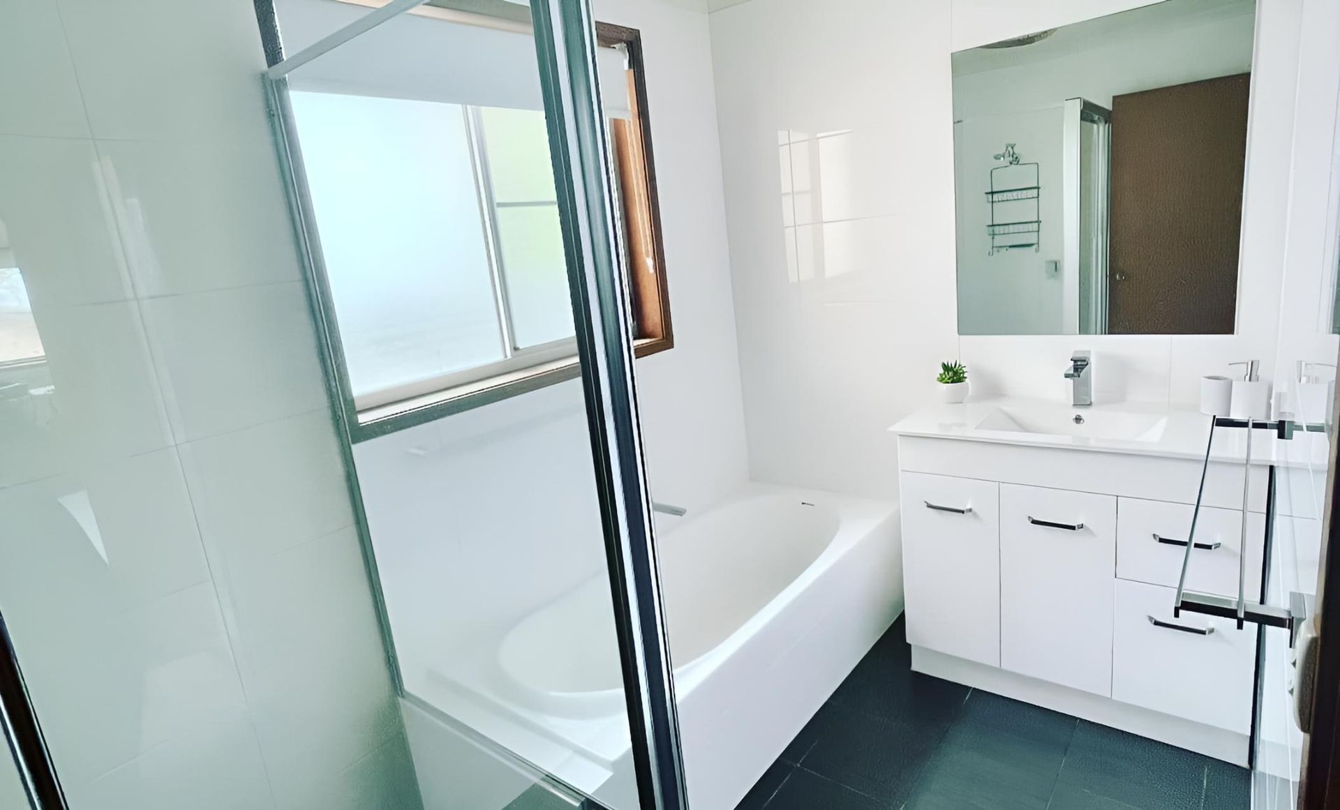Bathroom With a Bathtub, Sink, Mirror and Shower — Luke Barry Plumbing in Southport, QLD