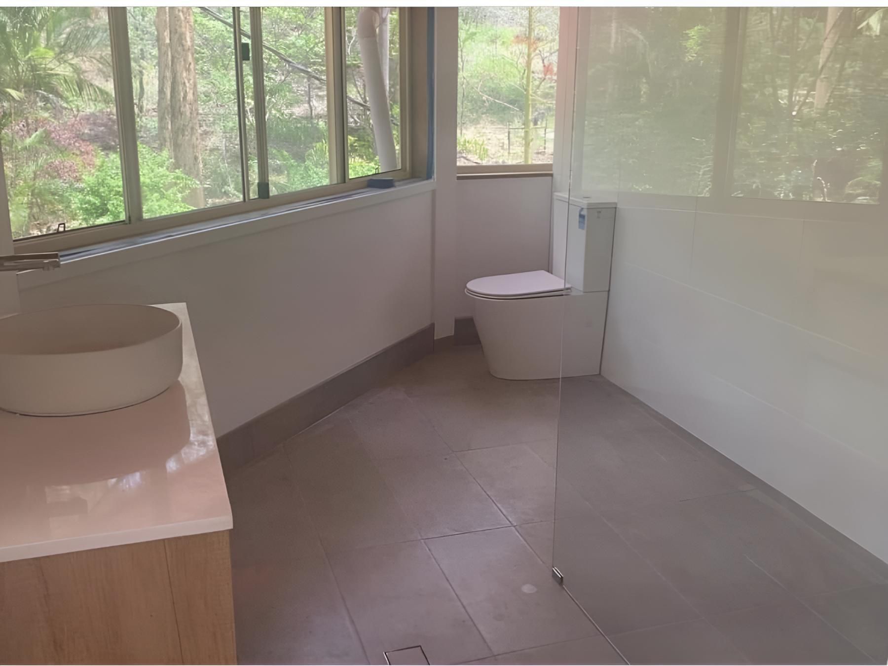 Bathroom With a Toilet, Sink, and Window — Luke Barry Plumbing in Sanctuary Cove, QLD