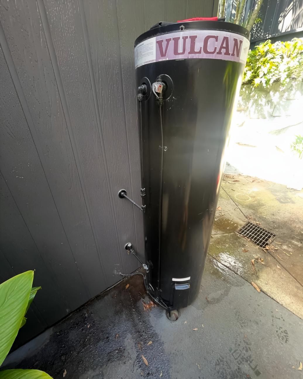 Black Vulcan Water Heater is Sitting on the Sidewalk — Luke Barry Plumbing in Pimpama, QLD