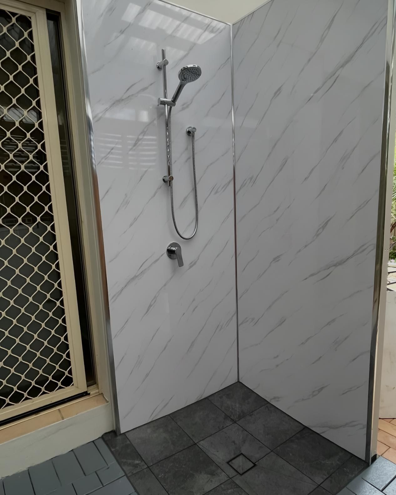 Shower With a Shower Head and a Marble Wall — Luke Barry Plumbing in Labrador, QLD