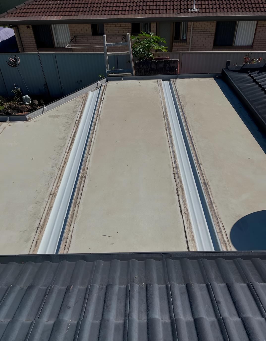 Roof of a House With a Ladder on Top of It — Luke Barry Plumbing in Upper Coomera, QLD