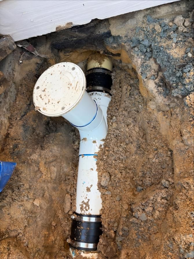 White Pipe is Sitting in the Dirt Under a House — Luke Barry Plumbing in Coomera, QLD