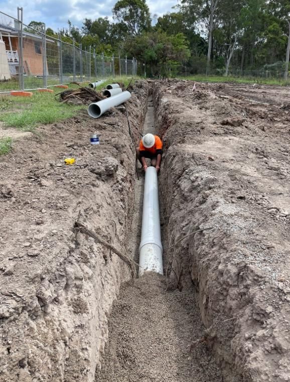 Man is Working on a Pipe in the Dirt — Luke Barry Plumbing in Varsity Lakes, QLD