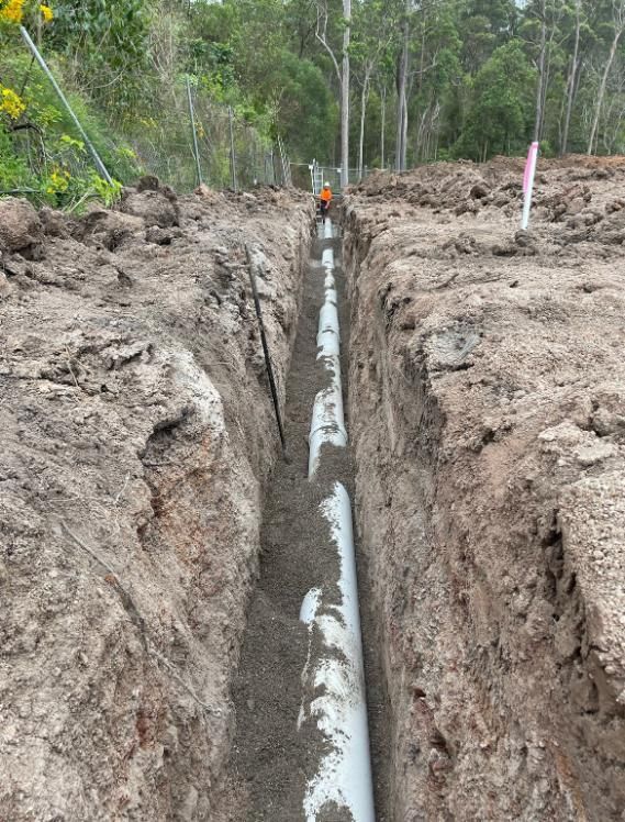 Pipe is Being Installed in a Trench in the Dirt — Luke Barry Plumbing in Miami, QLD