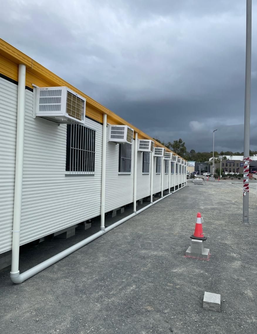 Row of Buildings With Pipe Plumbing on the Side — Luke Barry Plumbing in Mermaid Waters, QLD