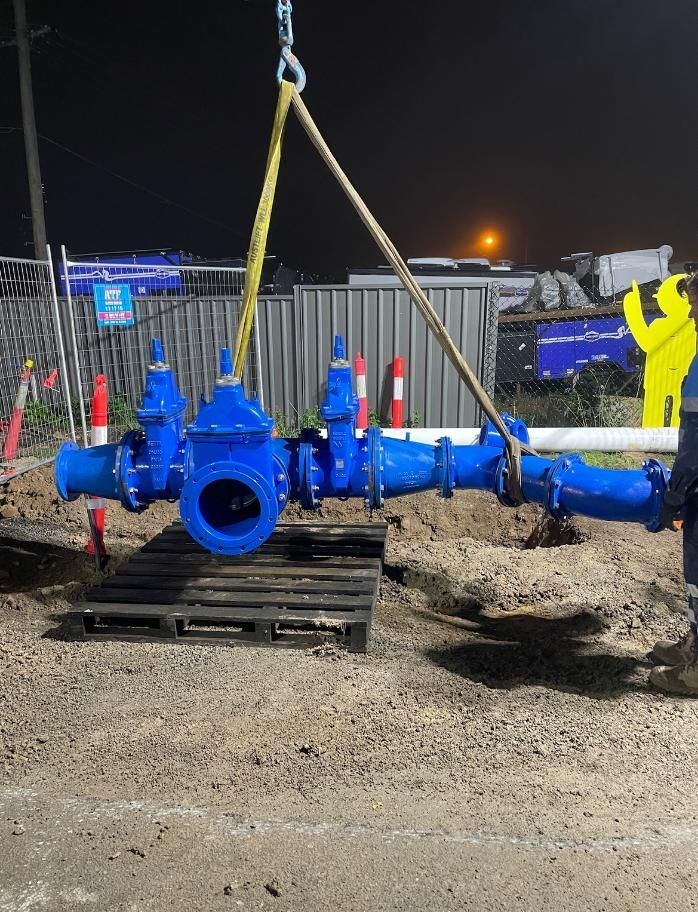 Blue Pipe is Being Lifted by a Crane — Luke Barry Plumbing in Varsity Lakes, QLD