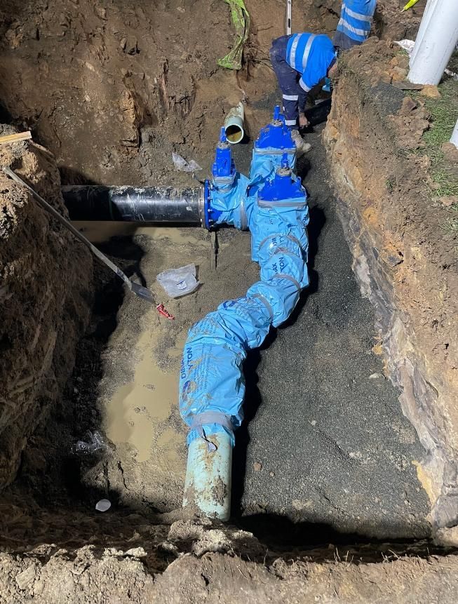 Man is Working on a Pipe in the Dirt — Luke Barry Plumbing in Burleigh Heads, QLD