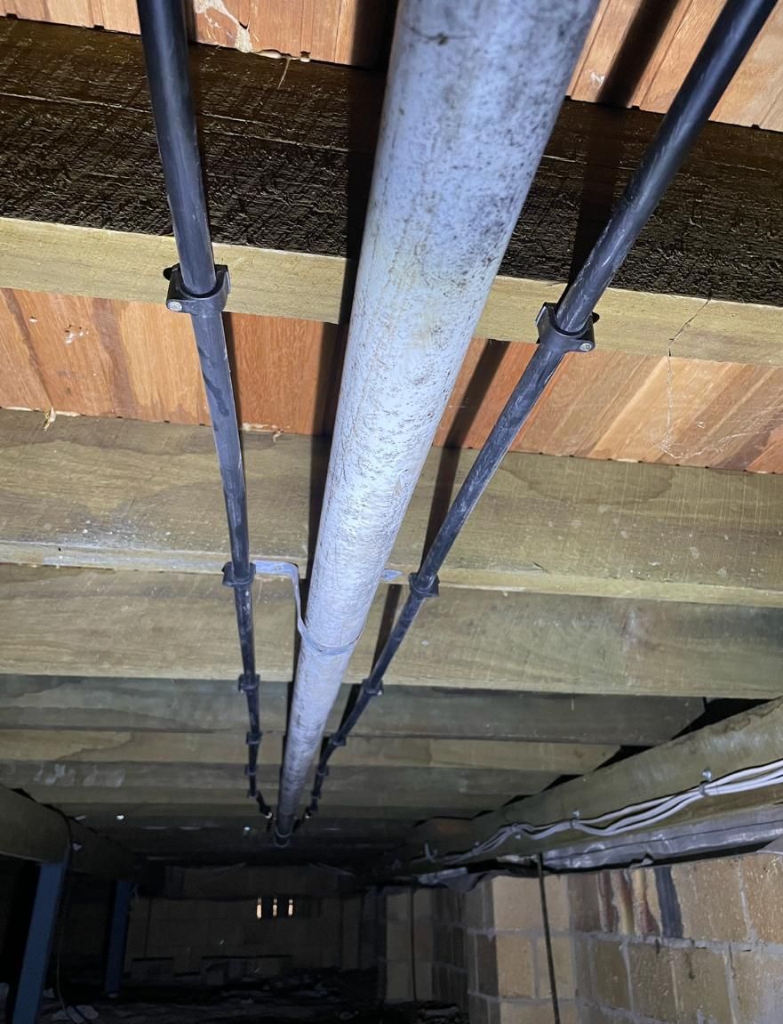 Pipe is Hanging From the Ceiling of a Building — Luke Barry Plumbing in Miami, QLD