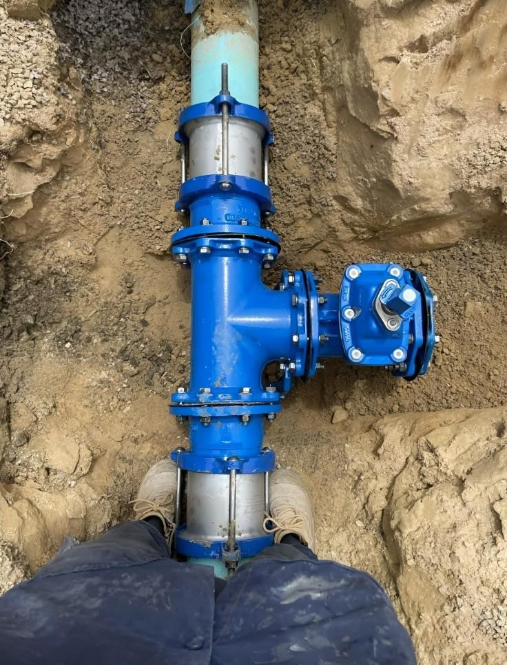 Person is Standing Next to a Blue Pipe in the Dirt — Luke Barry Plumbing in Mudgeeraba, QLD
