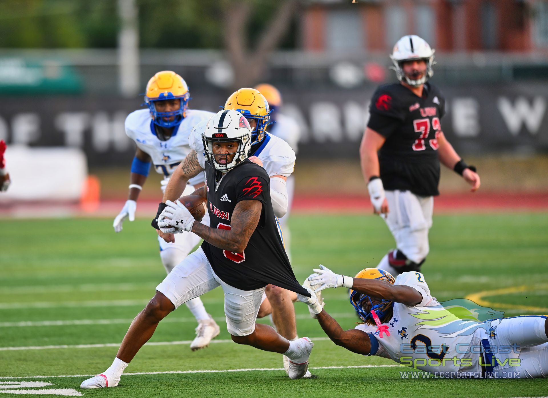 A group of football players are playing a game on a field.