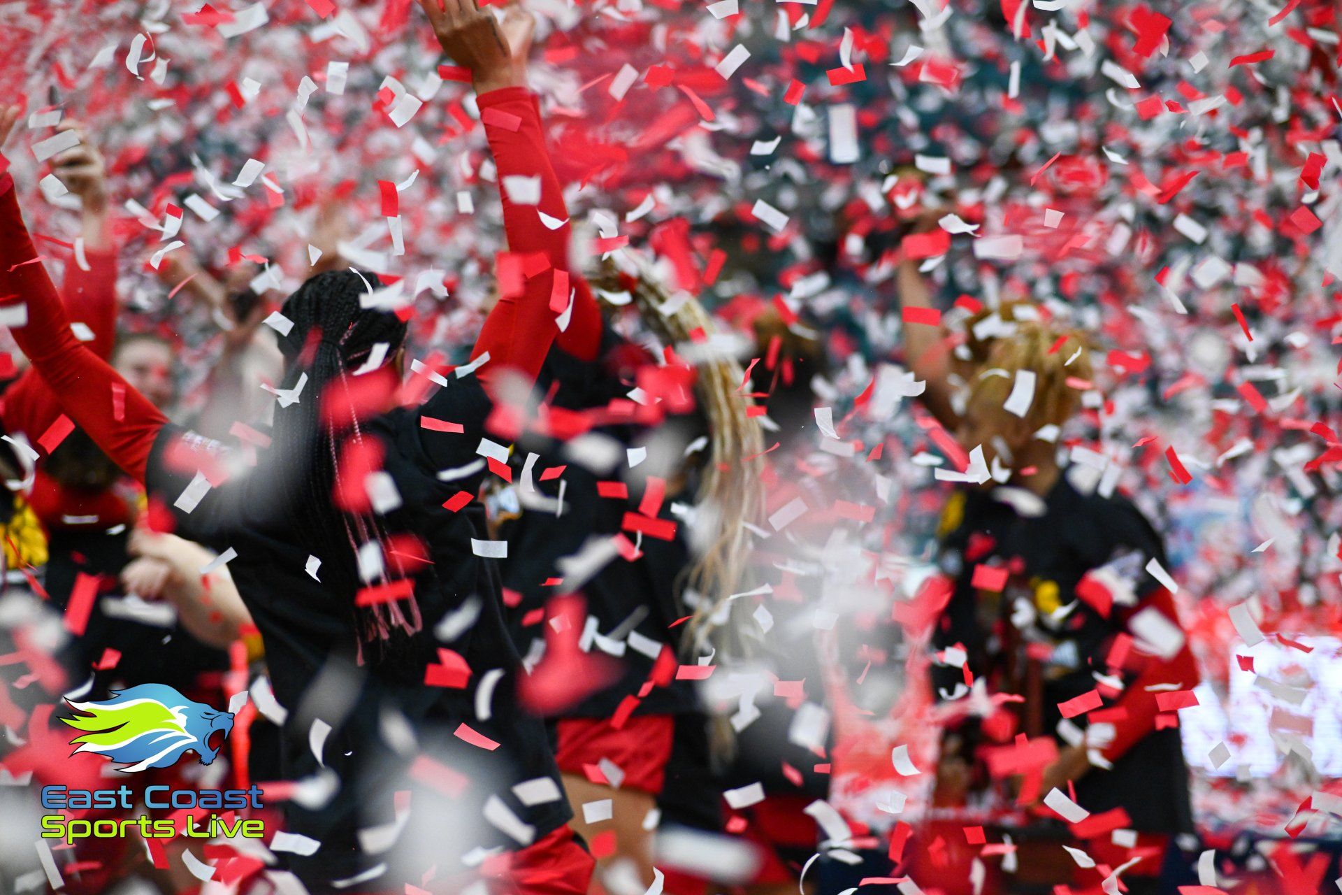 A group of people are surrounded by red and white confetti.