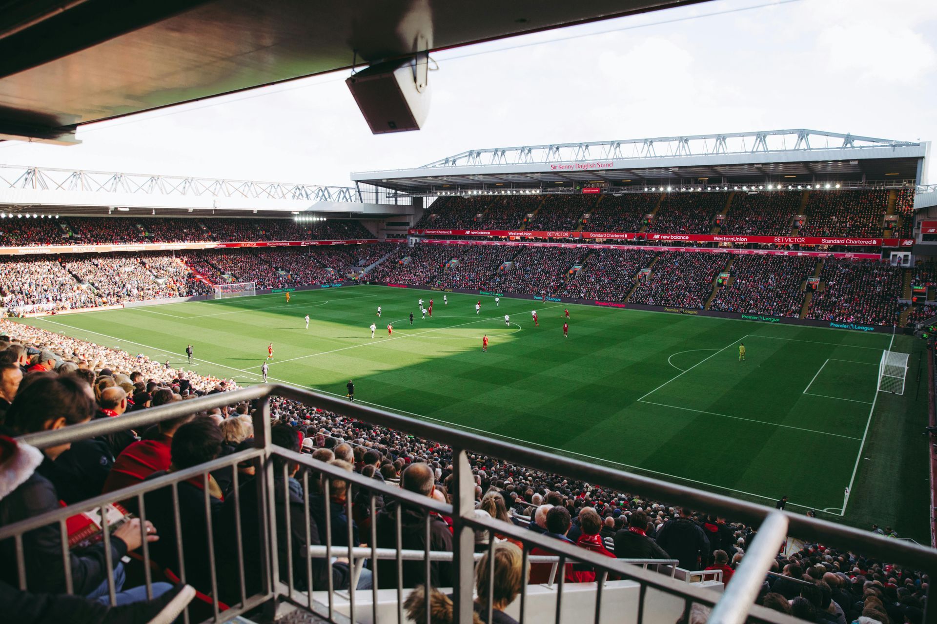 A crowd of people are watching a soccer game in a stadium.