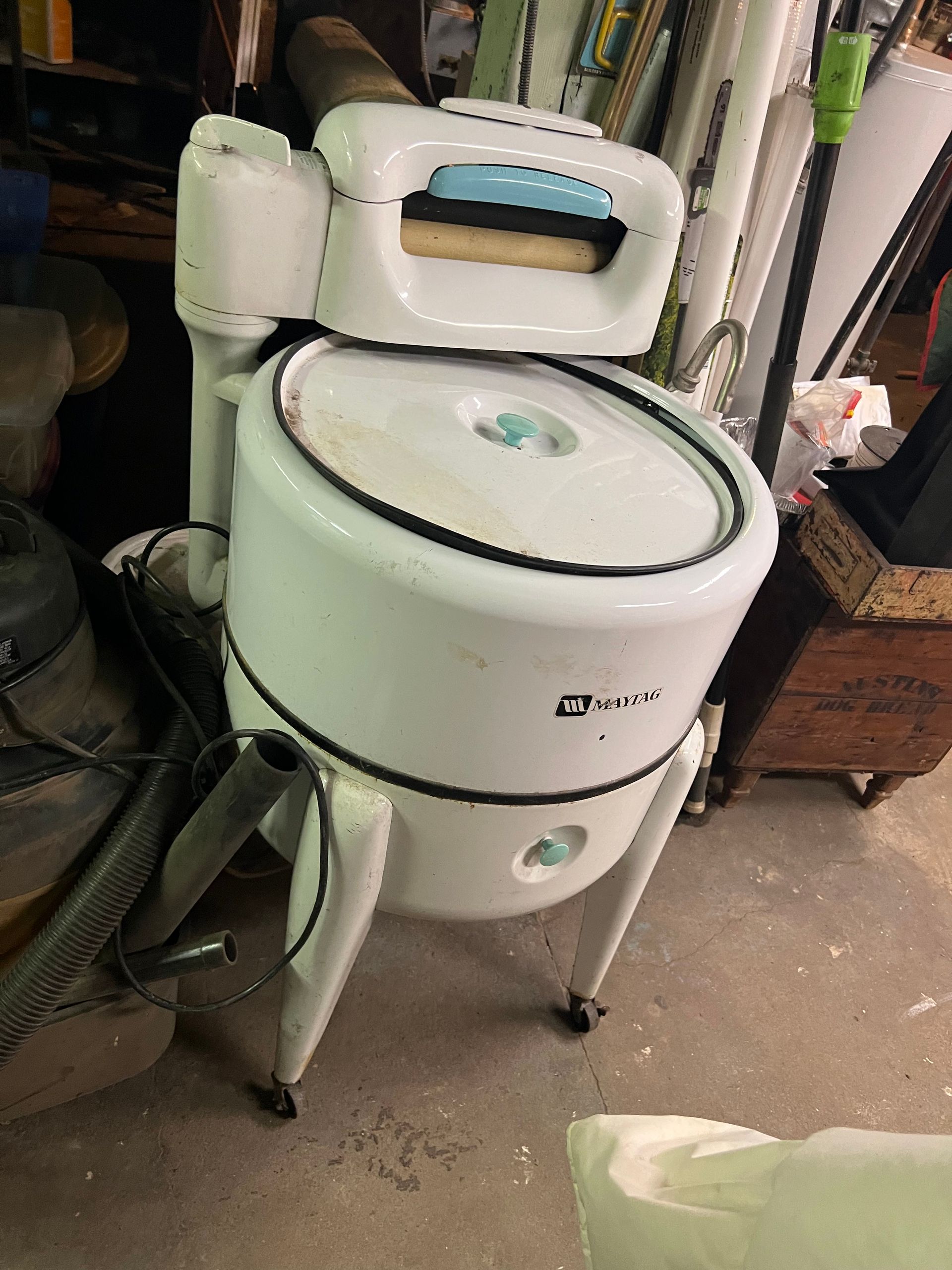 A white washing machine is sitting on the floor in a room.