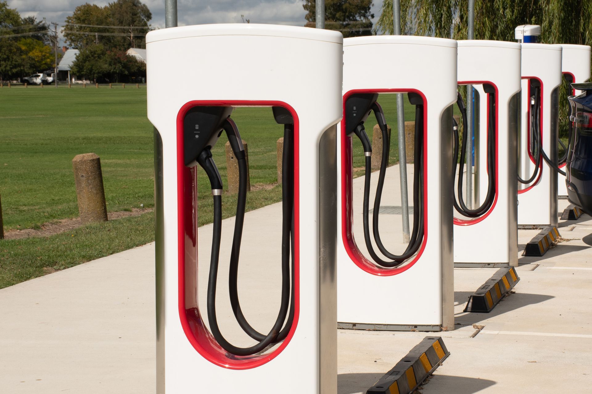A row of electric car charging stations in a parking lot.