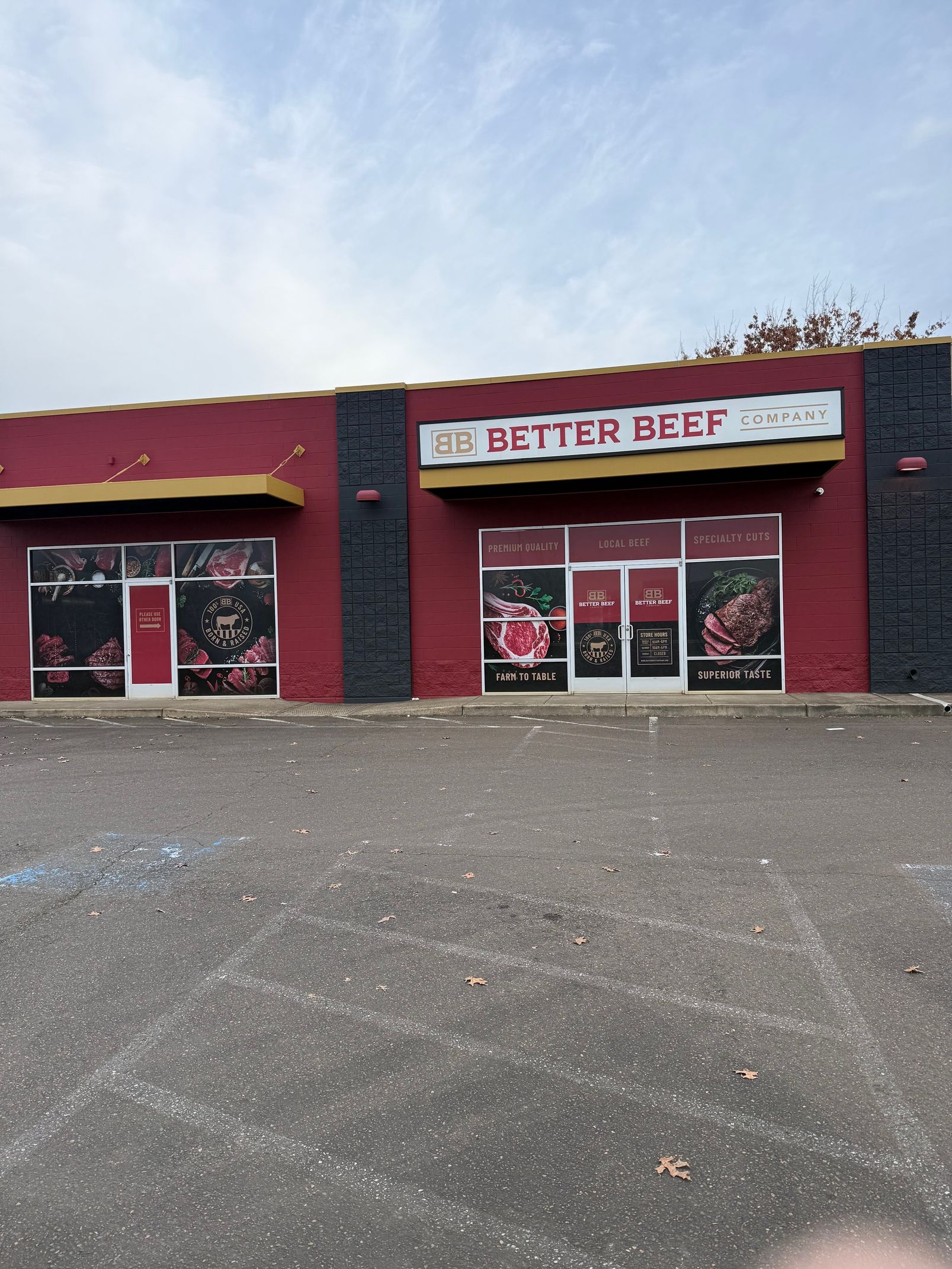 Storefront with a red-and-black exterior and a “BETTER BEEF” sign above glass doors.