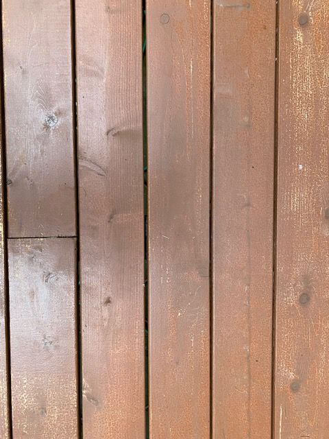 Vertical wooden planks in warm brown tones, with visible knots and weathered grain.