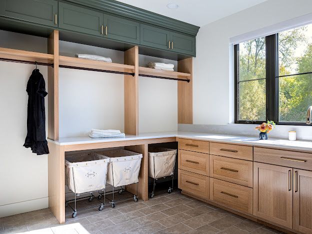 Built-in laundry room with wood cabinets, open shelving, countertop, and a window.
