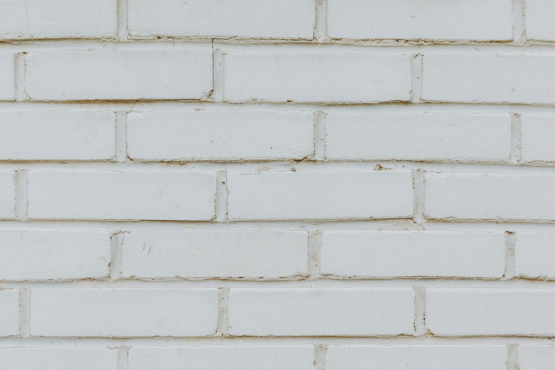 White painted brick wall with horizontal rows and light gray mortar lines
