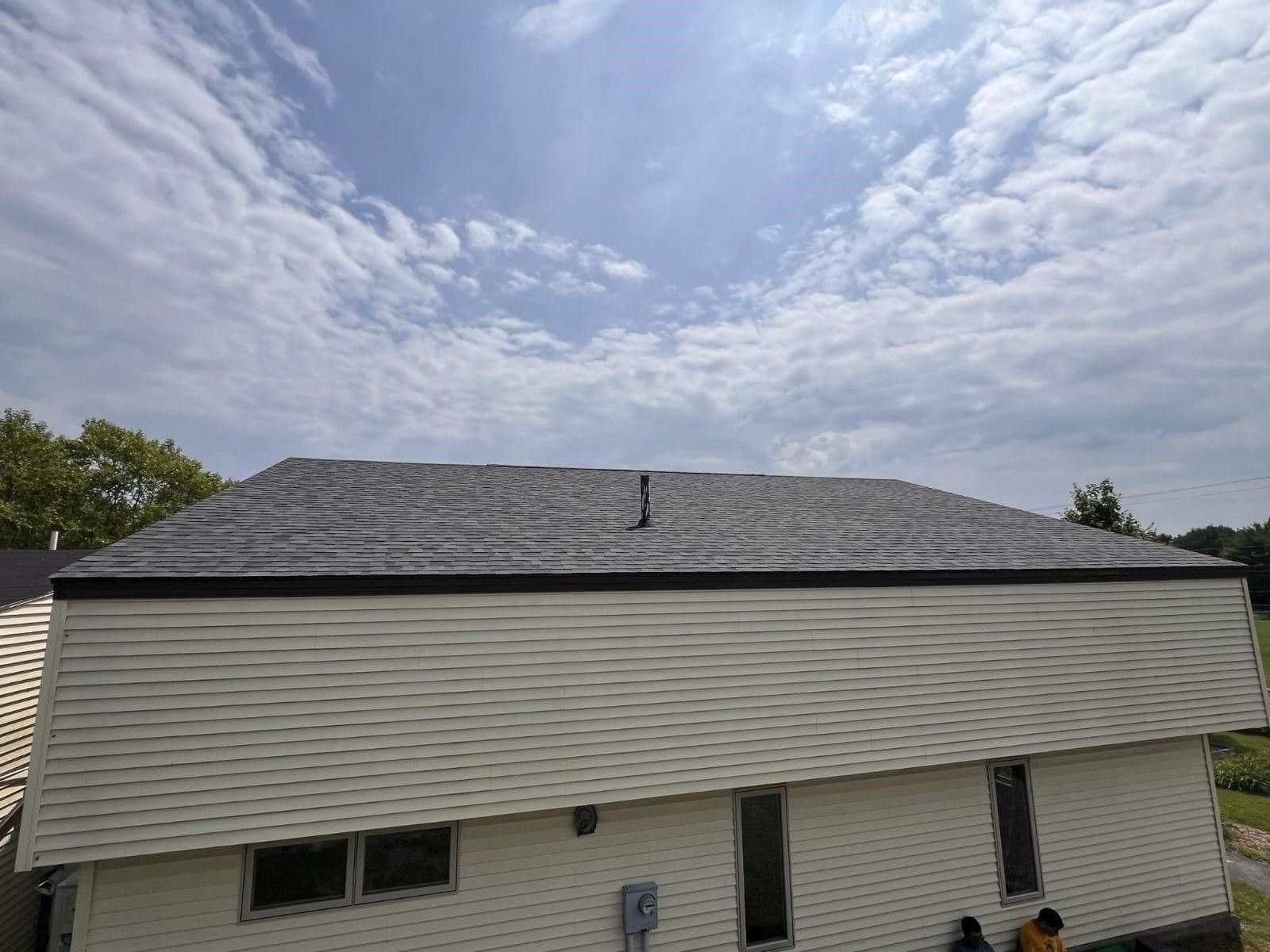A white house with a gray roof and a blue sky in the background.