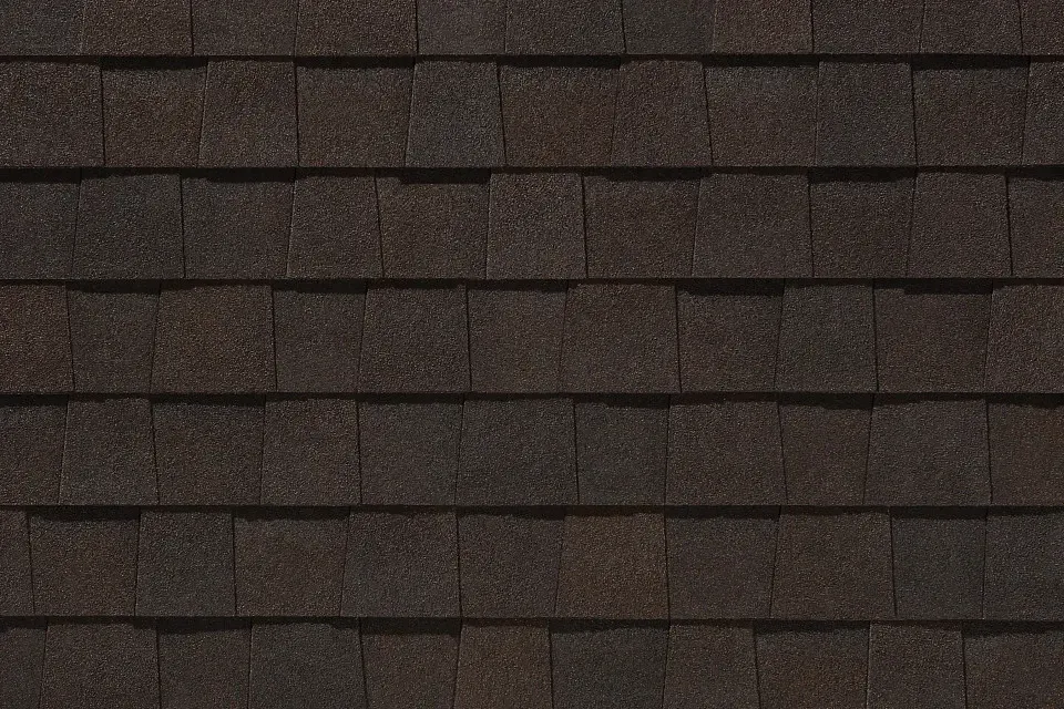 A close up of a roof with brown shingles.